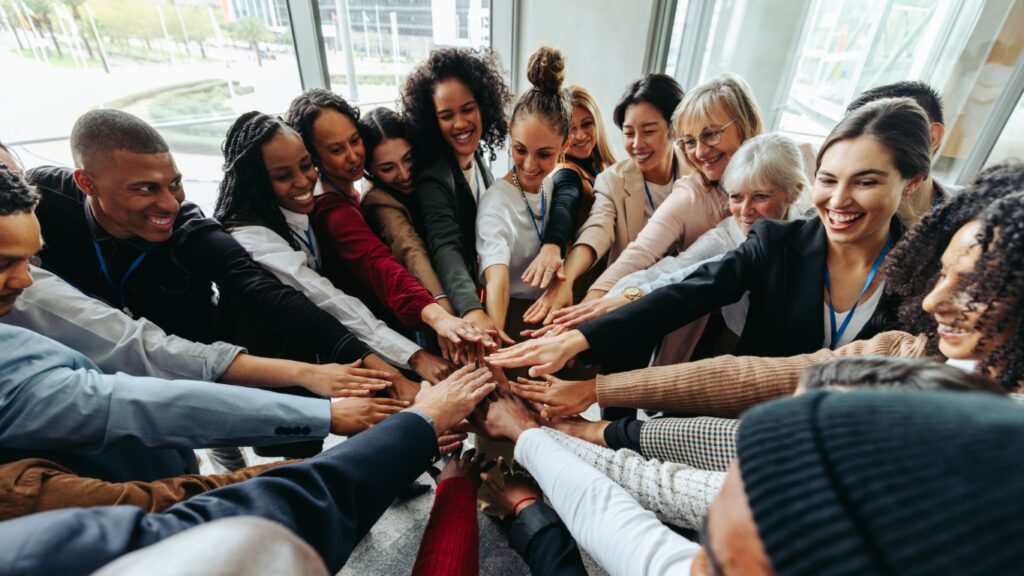 Successful team working together displaying unity and collaboration in an office environment with diverse backgrounds.